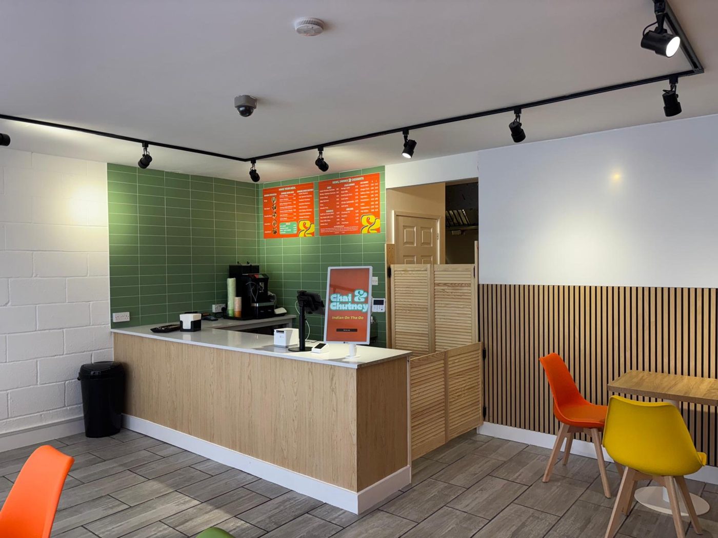 The green-tiled counter and colourful seating inside the shop